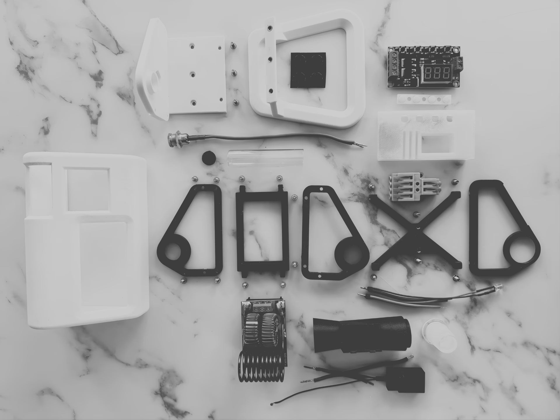 A photo of all the internal parts and pieces of a white mycology and lab tool sterilizer on a white gradient background