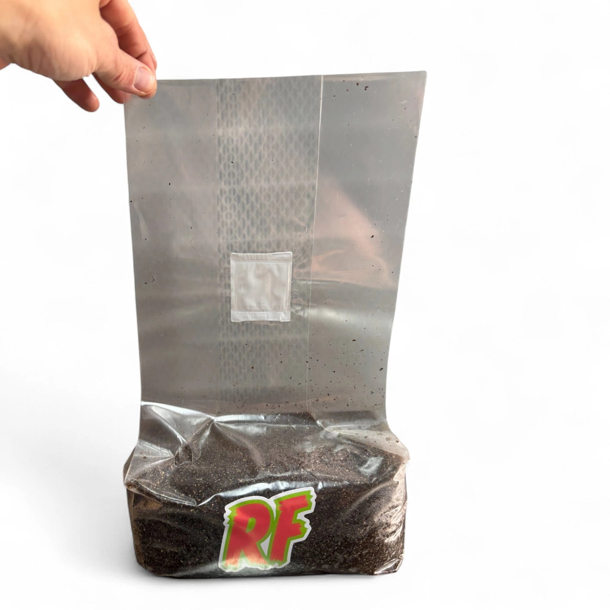 Hand holding a 3T unicorn bag filled with CVG substrate labeled 'RF' on a white background