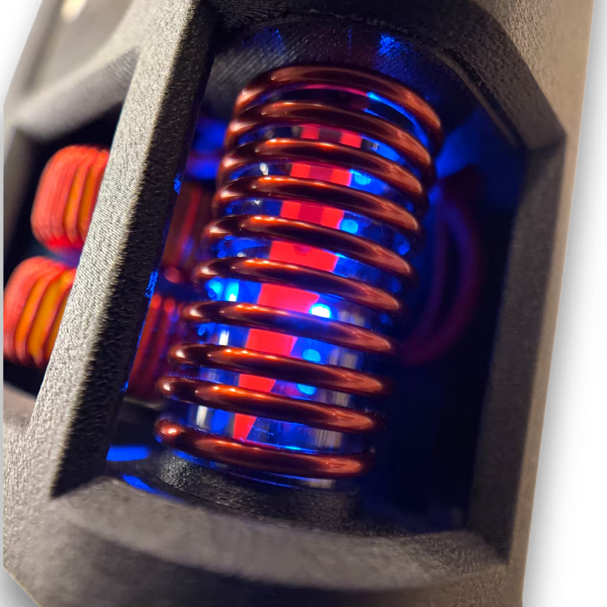 Close-up of the coil of a induction sterilizer heating a red hot scalpel blade  with a black housing