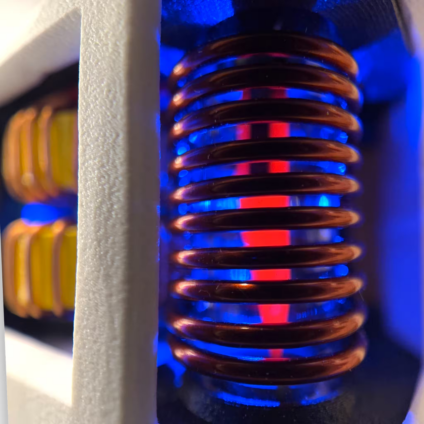 Close-up of a induction sterilizer coil heating a scalpel bright red with a blue LED in the background. 