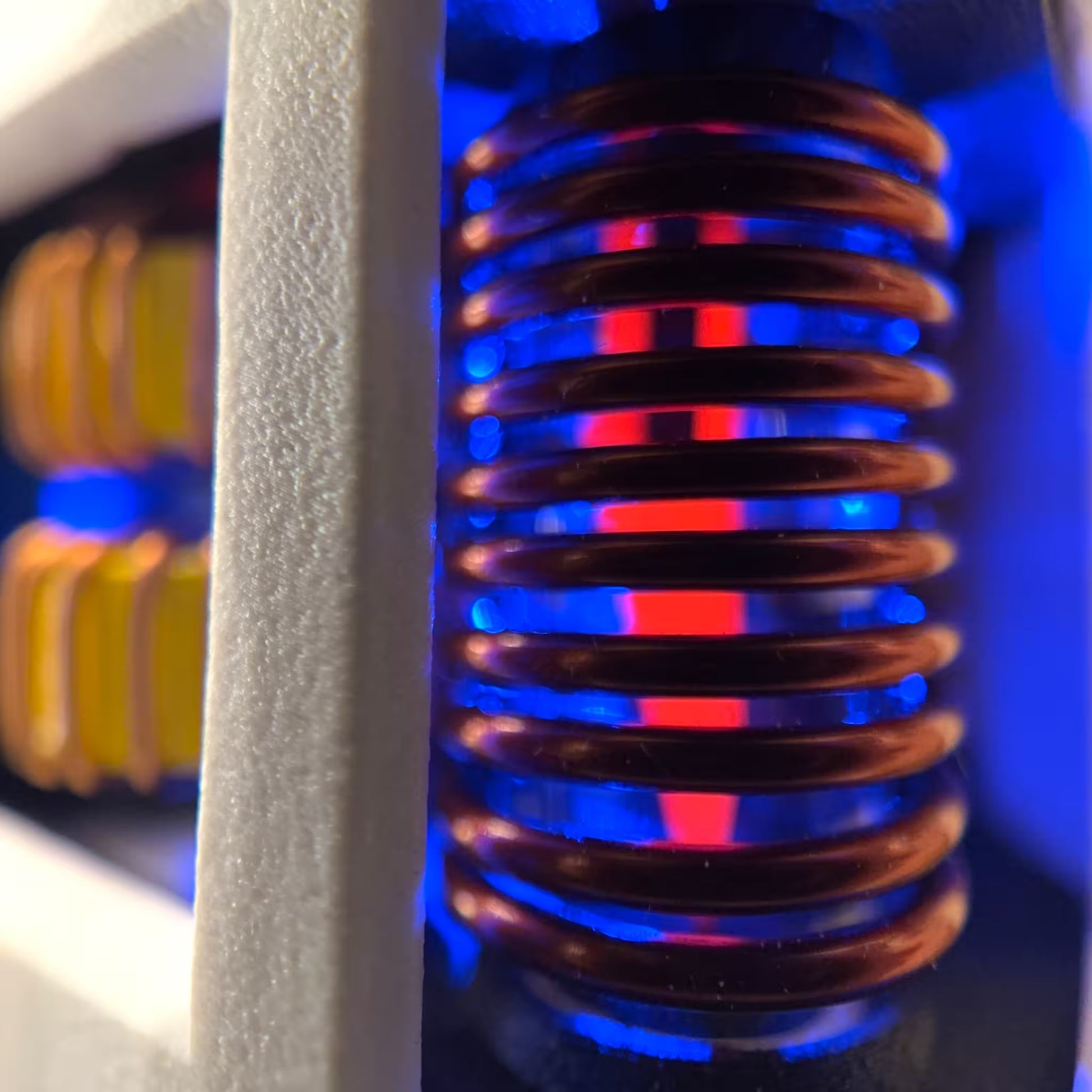 Close-up of an induction coil with blue and red hot scalpel with a white housing