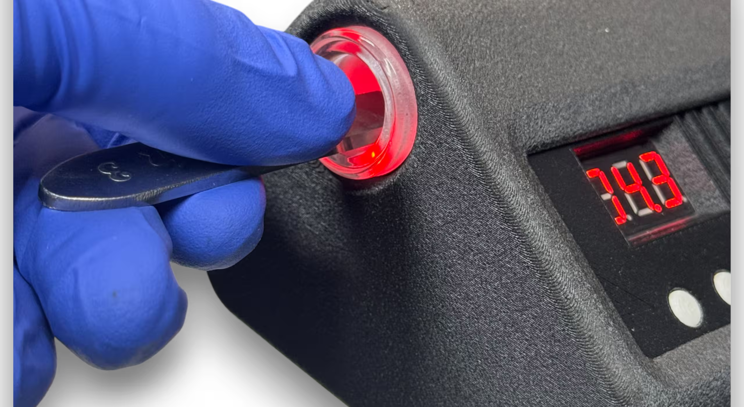 Scalpel being inserted into a Black Automatic Induction Sterilizer 